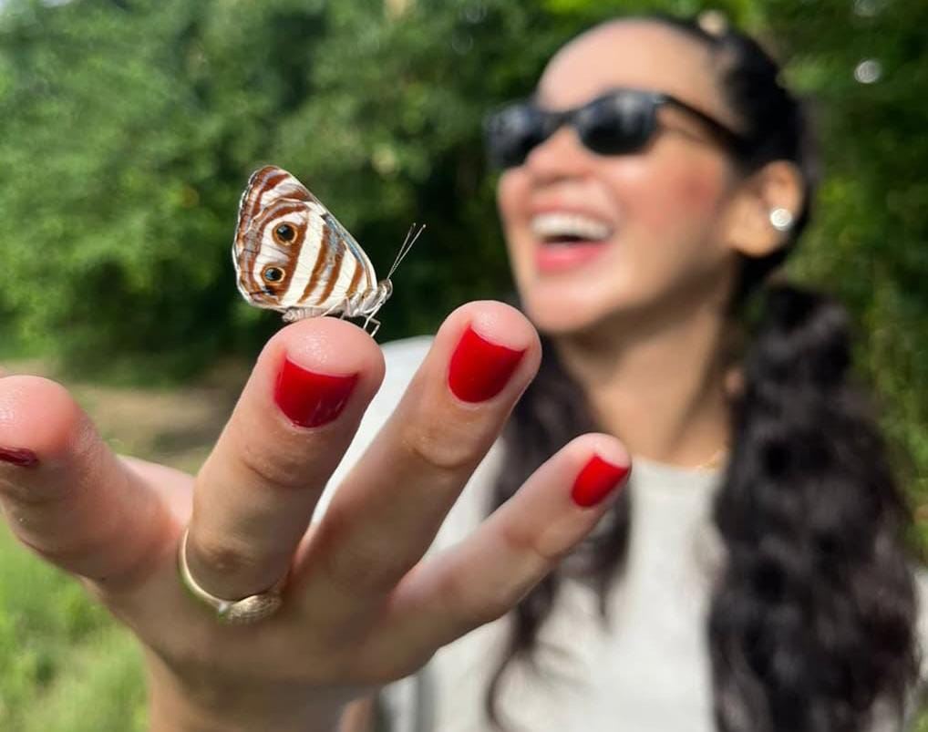 Viajera con una mariposa en la mano